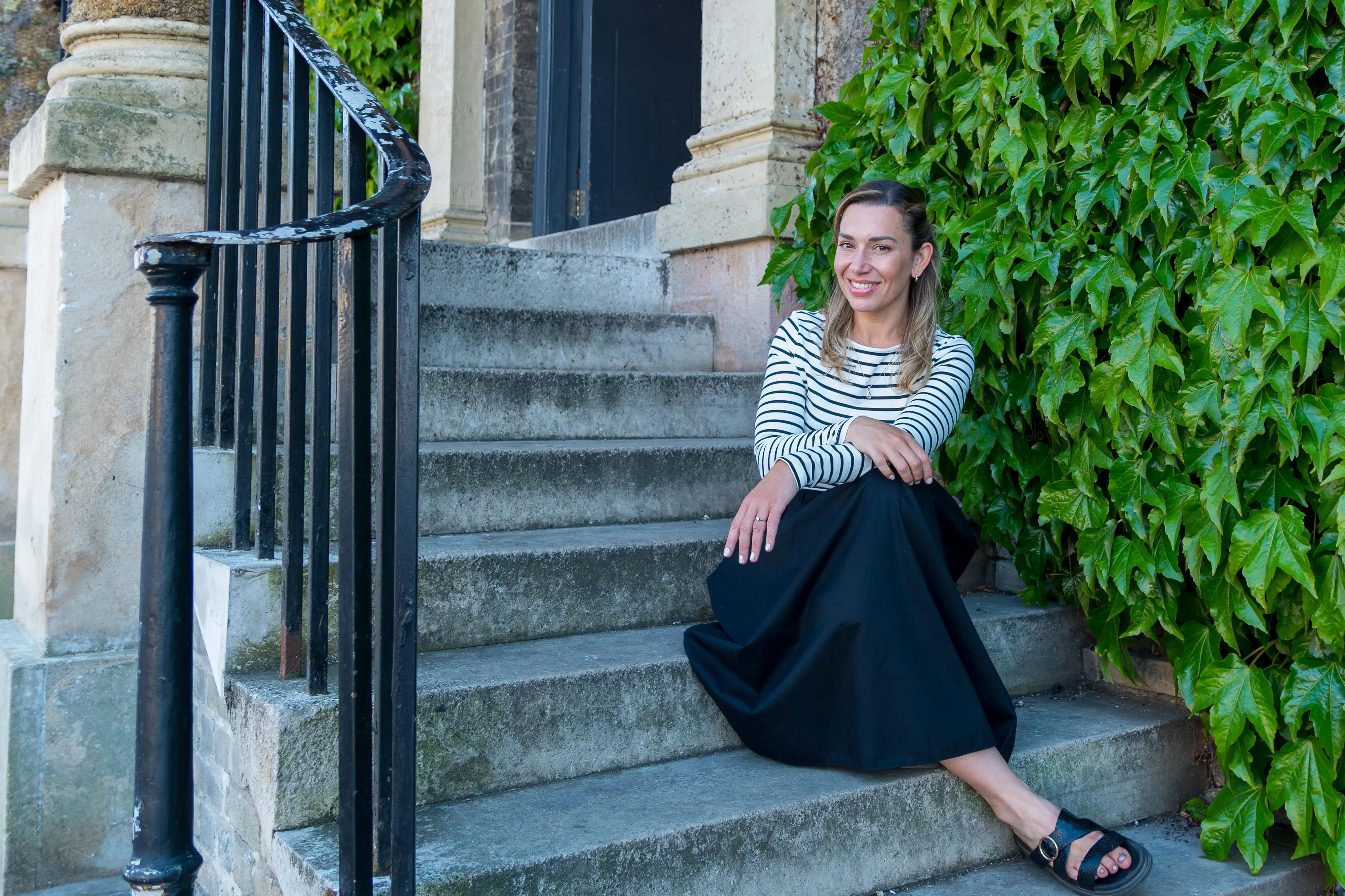 RI Coaching - Woman in relaxed pose on stone steps with natural lighting